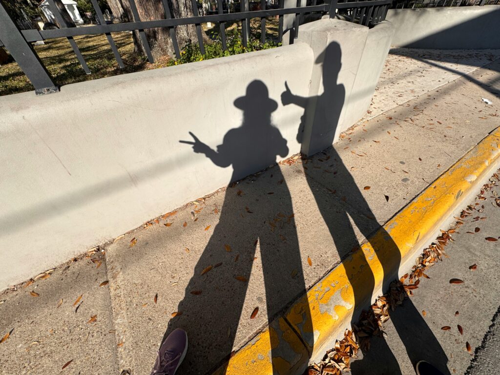 Differentiation: how we grow the muscles of connection and selfhood at the same time. Two people's shadows stand playfully side by side.